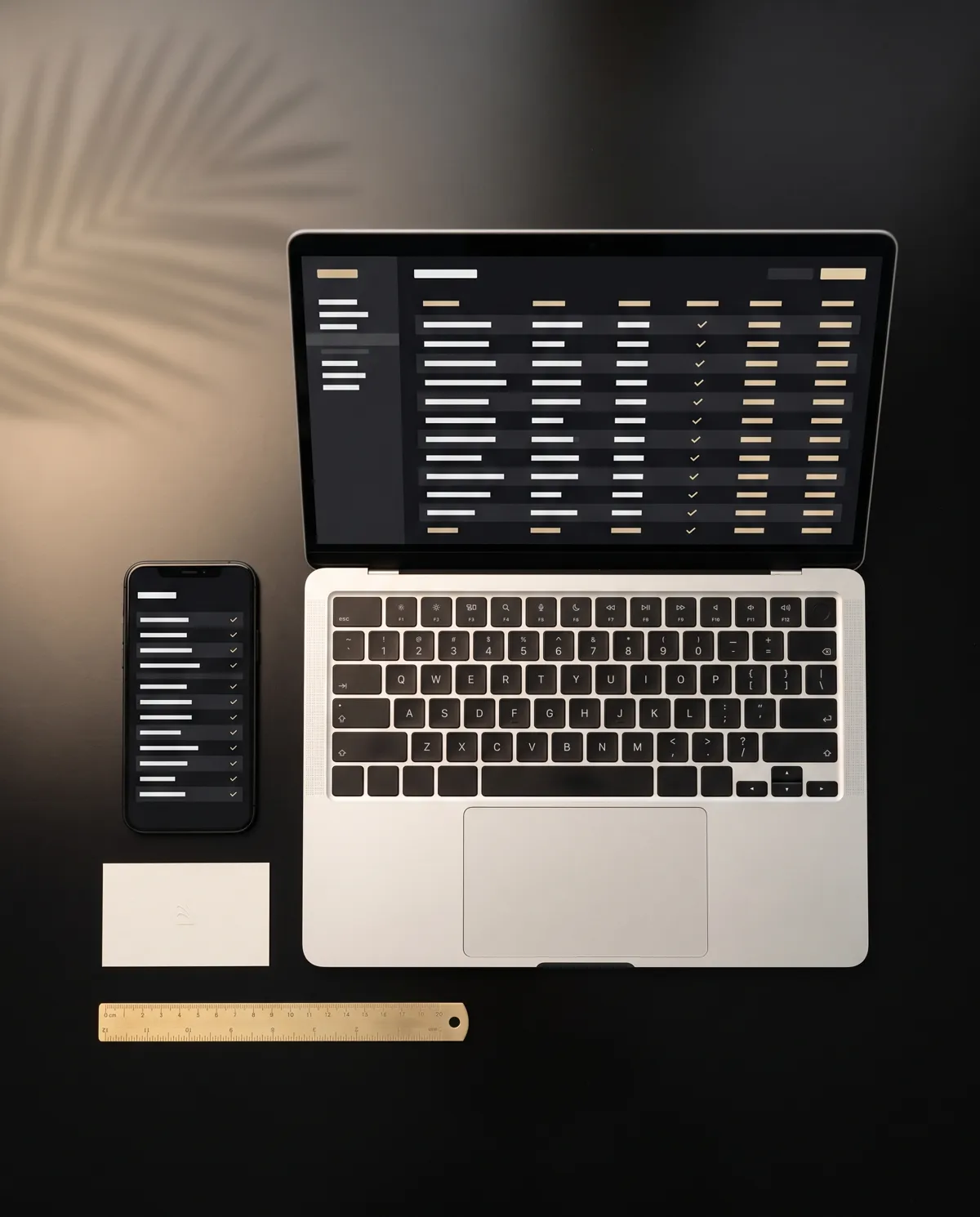 Laptop and phone showing reconciled accounts, aligned on a black desk